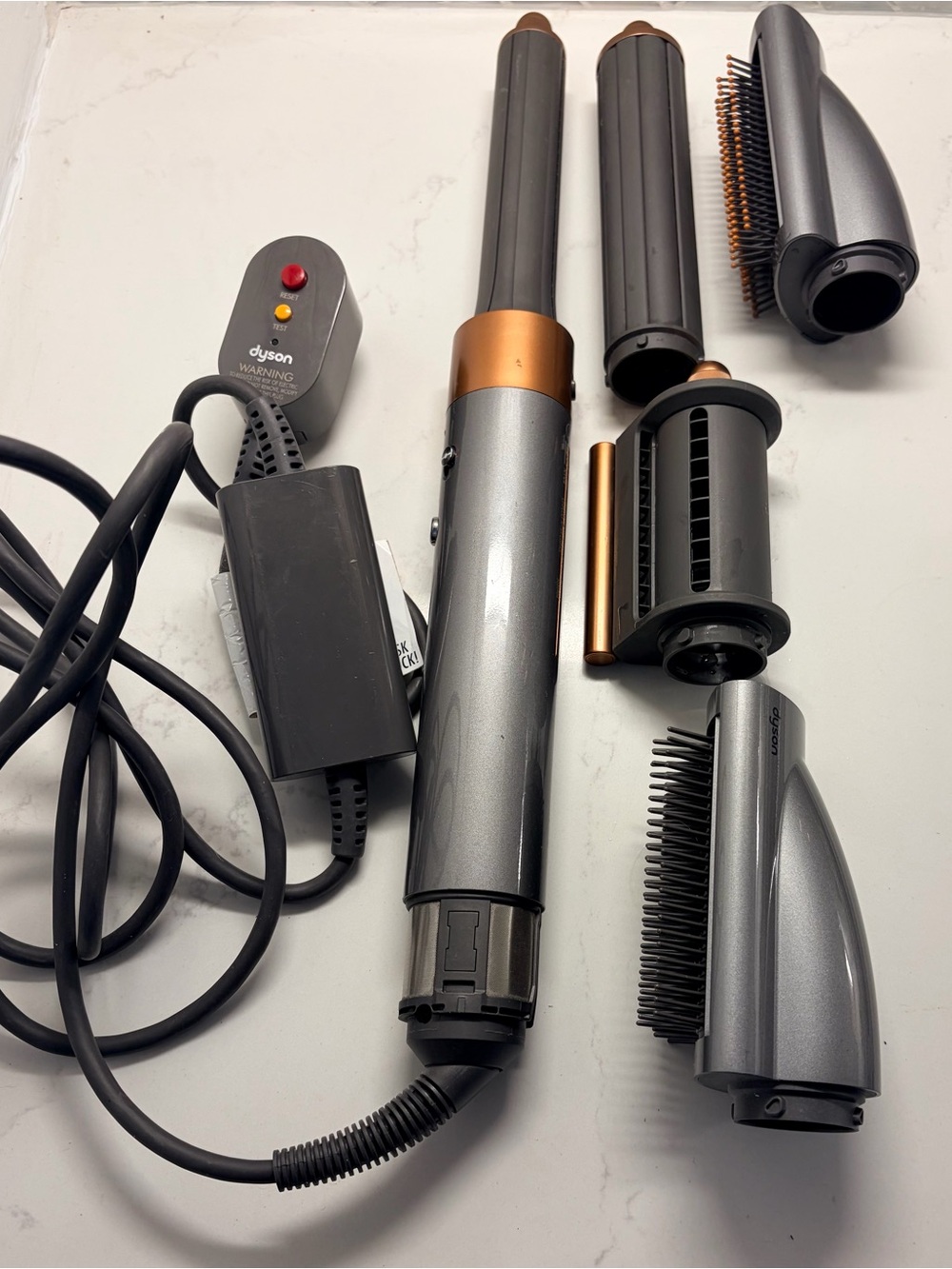 Dyson hair styler attachments in gunmetal gray and copper accents